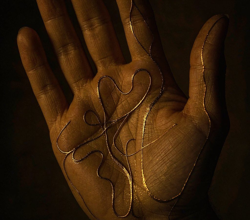 An open palm with fine golden lines traced over it